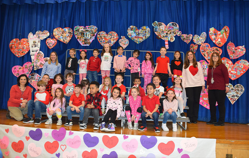 People standing on a stage surrounded by drawn hearts