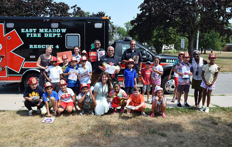 students and adults posing in front of ambulance
