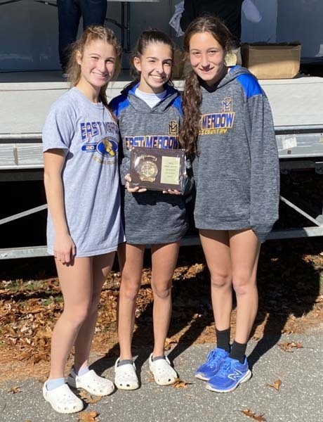 Three students holding an award and smiling