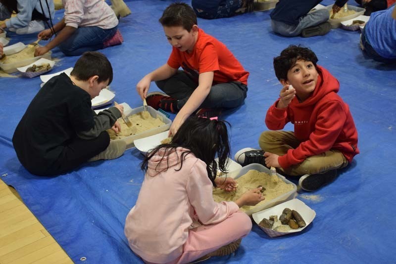 Students digging up fossils in the gym