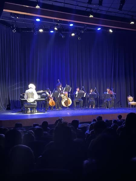 “Meeting Mozart” concert being performed on a stage while students watch