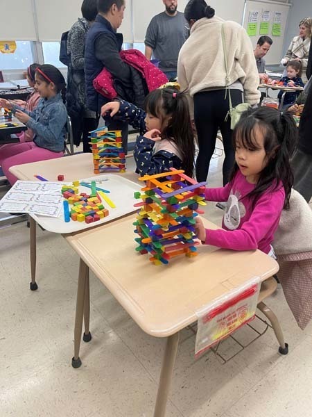 Two students stacking materials on their desks