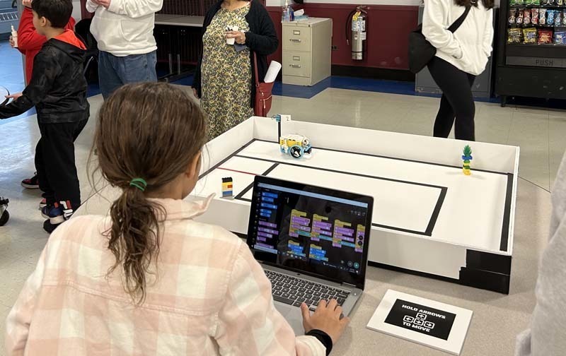 A student using a computer to control a robot