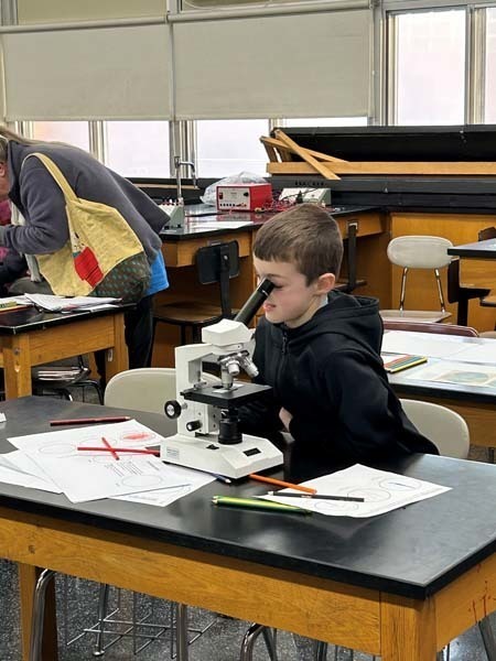 A student looking through a microscope