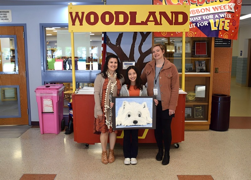 Anneliese Blakeman holding artwork with her art teacher Mrs. Christina Valenti-Linares, left, and District Art Department Chairperson Heather Anastasio